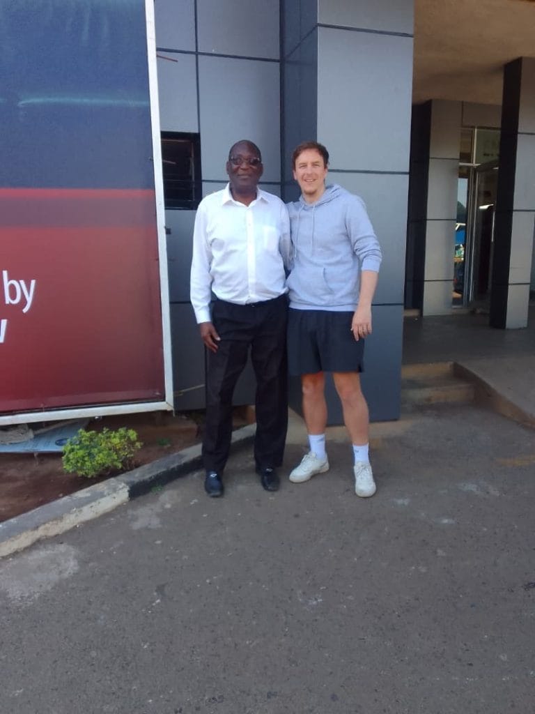 Adam meeting a school leader in Malawi